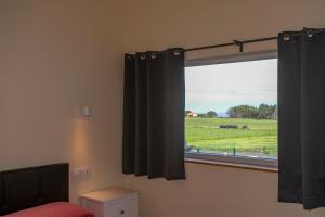 PimiangoApartamentos Rurales Miramar的一间卧室设有窗户,享有田野美景