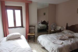 SellaVilla Pico的一间卧室设有两张床、一个窗口和镜子