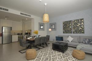 迪拜bnbmehomes - Elegant 3 BR - Dubai South - G04的客厅配有沙发和桌子