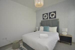 迪拜bnbmehomes - Elegant 3 BR - Dubai South - G04的卧室配有白色大床和灯