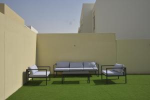 迪拜bnbmehomes - Elegant 3 BR - Dubai South - G04的大楼里三把椅子和一张长凳