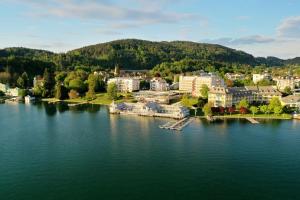 沃尔特湖畔佩莎赫Werzers Hotel Resort Pörtschach的享有湖泊上城镇的空中景致