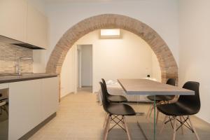 巴斯蒂亚乌姆布拉Assisium Appartamenti的厨房以及带桌椅的用餐室。