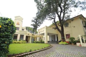 科钦Amritara The Poovath Beachfront Heritage, Fort Kochi的车道中间有树的建筑物