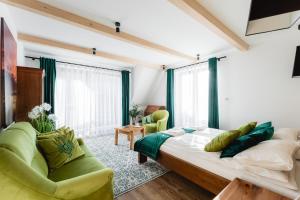 扎科帕内Zakopane Apartamenty 4 Seasons的一间卧室配有一张大床和两张绿色椅子