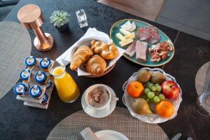 Saint Aubin SaugesHôtel Restaurant Port-Conty的餐桌上摆放着早餐食品和橙汁盘