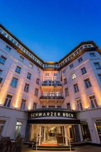 威斯巴登威斯巴登施瓦泽博克丽笙酒店的一座白色的大建筑,上面标有读《扫 ⁇ 书》的标志
