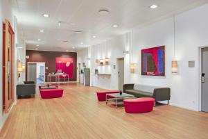 锡尔克堡锡尔克堡造纸厂丽笙酒店的带沙发和红色椅子的客厅