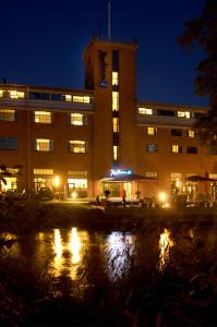 锡尔克堡锡尔克堡造纸厂丽笙酒店的一座在水中反射的夜间建筑