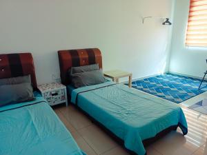 居銮Homestay DTepian Bayu Bandar Seri Impian Kluang的一间卧室设有两张床、一张桌子和一个窗口