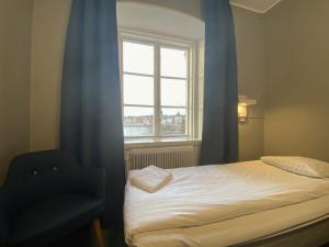 斯德哥尔摩瑞典旅游的查普曼和思科普索尔门国际青年旅舍的一间卧室设有一张床、一个窗口和一把椅子