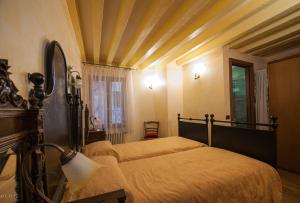 威尼斯Ca' degli Artisti的一间卧室设有两张床和天花板