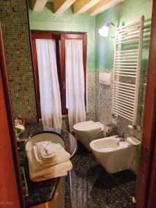 威尼斯Ca' degli Artisti的浴室配有盥洗盆、卫生间和盥洗盆。
