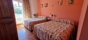 Punta DelgadaLa Elvira Natural Lodge的酒店客房设有两张床和窗户。