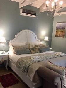 比勒陀利亚Morgenzon Estate的卧室配有一张带吊灯的大型白色床。