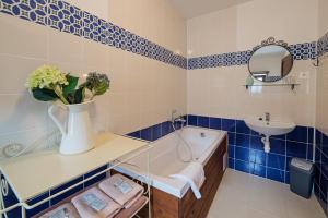 班斯卡 - 什佳夫尼察老客栈膳食公寓酒店的蓝色和白色的浴室设有浴缸和水槽
