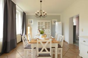 博尔滕哈根Ferienhaus für 8 Personen mit Kamin & Terrasse的厨房以及带白色桌椅的用餐室。