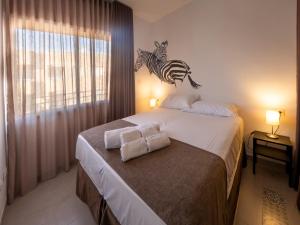 贝尼卡洛Las Cebras Apartamentos Turísticos的一间卧室配有一张床,上面有两条毛巾