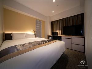 熊本Daiwa Roynet Hotel Kumamoto的一间酒店客房,配有一张大床和一台平面电视