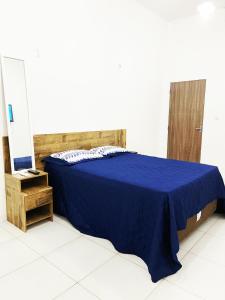 马卡帕Aeroporto House 4的一间卧室配有蓝色的床和镜子