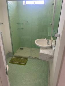 彼得罗波利斯Apartamento Inteiro com Vista do Lago Quitandinha的一间带水槽和玻璃淋浴的浴室