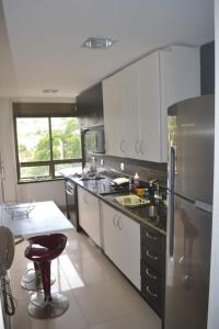 彼得罗波利斯Apartamento Inteiro com Vista do Lago Quitandinha的厨房配有不锈钢冰箱和水槽