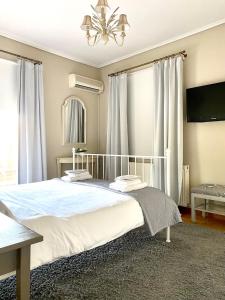 雅典阿马鲁西奥精品公寓的卧室配有一张带吊灯的大型白色床。