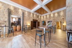 巴尔武埃纳德杜埃罗Castilla Termal Monasterio de Valbuena的一间设有石墙和酒吧凳子的品酒室