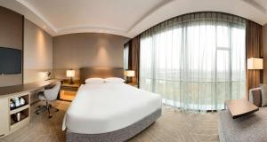上海上海虹桥商务区凯悦嘉轩酒店的卧室配有一张白色大床和电视。