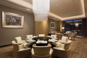 上海上海虹桥商务区凯悦嘉寓酒店的一间带桌椅和吊灯的用餐室