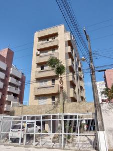马蒂尼奥斯Apartamento em Caioba com wi-fi的一座高大的建筑,前面有一棵棕榈树