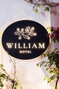 塔斯科·德·阿拉尔孔William Hotel Boutique De Diseño的建筑物一侧的柳条旅馆标志