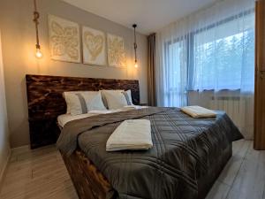 波罗维茨Borovets Gardens B30 Morunov Apart的一间卧室配有一张大床和两条毛巾