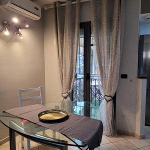 里米尼Chic & Relax apartment的一间设有玻璃桌和窗户的用餐室