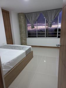 马尼萨莱斯Apartamento vacacional FL Martinz的一间卧室设有一张床和一个大窗户