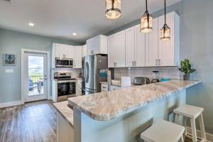 多芬岛Newly Built DAUPHIN ISLAND Home!的厨房配有白色橱柜和大型大理石台面