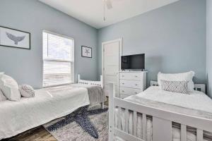 多芬岛Newly Built DAUPHIN ISLAND Home!的一间卧室设有两张单人床和一台电视机。