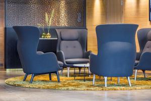 特罗姆瑟特罗姆瑟丽笙布鲁酒店的一间设有蓝色椅子和桌子的等候室