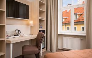 里加Radisson Hotel Old Town Riga的酒店客房设有书桌和窗户。