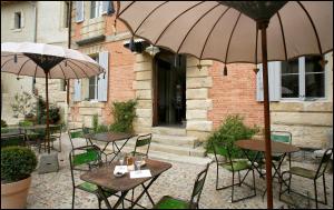 于泽斯高棉科特迪瓦于泽斯住宿加早餐旅馆的户外庭院配有桌椅和遮阳伞。