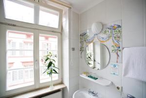 海德堡高登赫克特酒店的一间带水槽和镜子的浴室以及窗户。