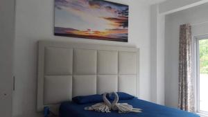 特鲁欧克比赫斯Villa Emita Trou aux Biches Beach Appartement的卧室配有一张蓝色的床,墙上挂着一幅画