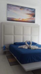 特鲁欧克比赫斯Villa Emita Trou aux Biches Beach Appartement的一间卧室配有一张蓝色的床,上面有弓