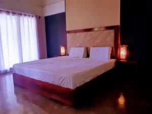 卢纳将军城Lagkaw Siargao Villas的一间卧室配有一张大床和两盏灯