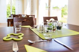 迪森阿姆阿梅尔塞阿默尔湖酒店的一张带绿色餐巾和玻璃杯的木桌