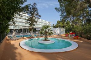 圣安东尼奥湾Els Pins Resort & Spa - Emar Hotels的一座建筑中间的一座棕榈树游泳池