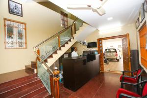 坦贾武尔RAMANA'S HOME STAY Apartment Hotel Kumbakonam的楼梯,房子里的人站在桌子旁