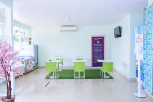 雅加达Cordex Hotel Ancol的一间医院间,配有绿色椅子和桌子