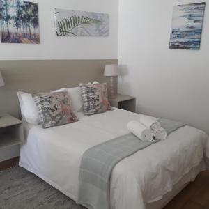 哈博罗内Aflica Apartments的卧室配有白色床和毛巾