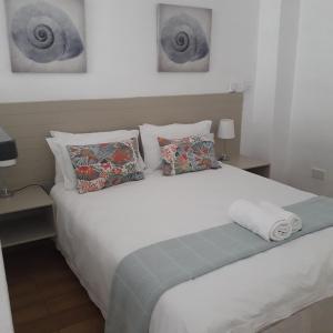 哈博罗内Aflica Apartments的卧室配有带枕头的大型白色床
